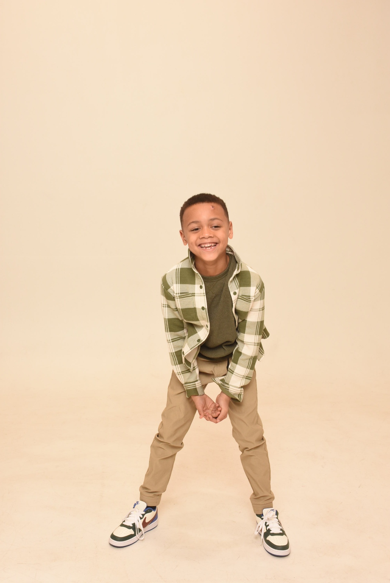 Young boy smiling in a green plaid shirt
