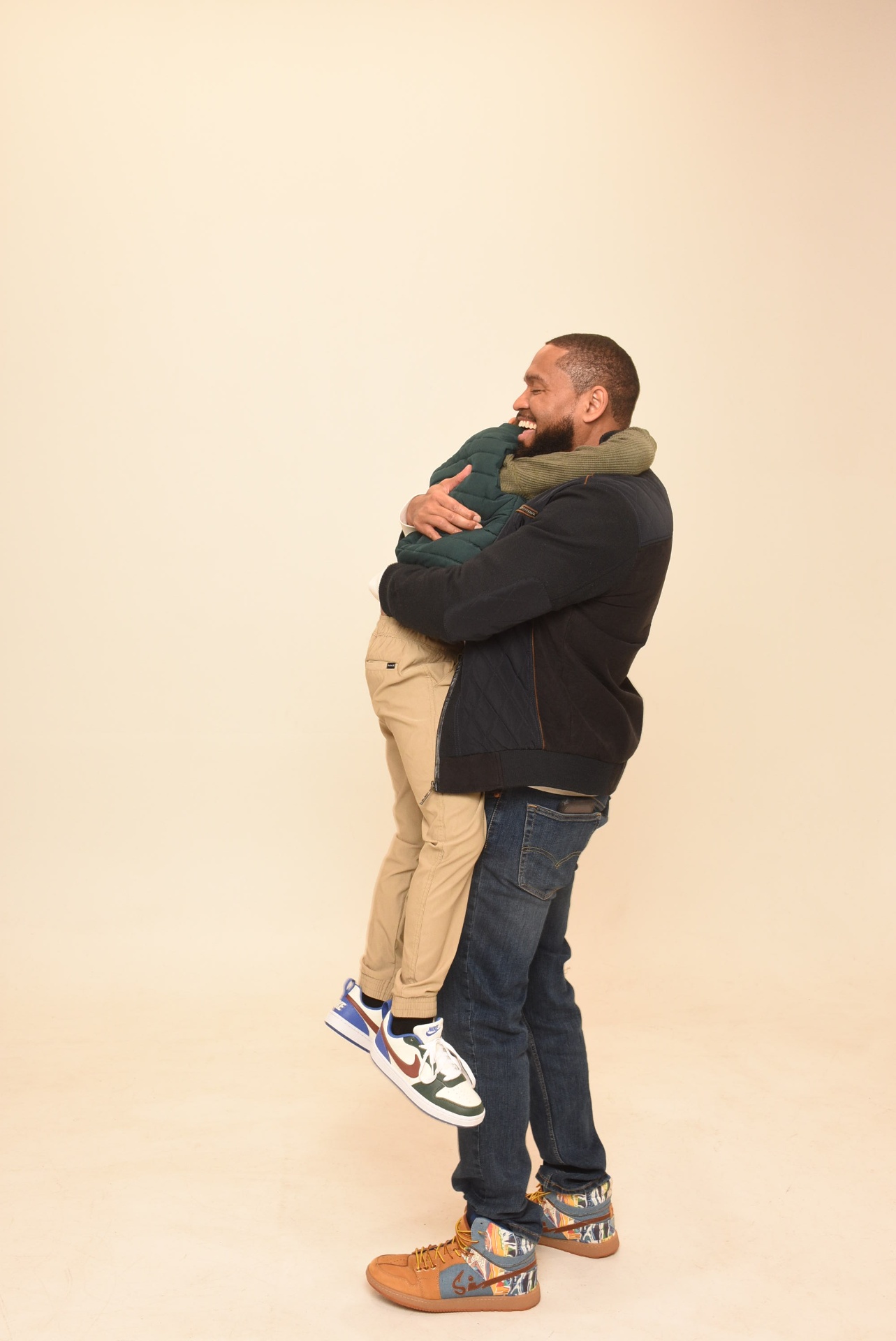 Father lifting and hugging his son, both laughing